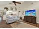 Living room features hardwood floors, a ceiling fan, a sofa, and a television atop a wooden cabinet at 2806 Fairway View Dr, Valrico, FL 33596