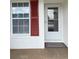 Close-up of a front entry door with red shutters and a welcome mat for a warm invitation at 3007 Wainwright Ct, New Port Richey, FL 34655