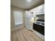 Bright kitchen with white cabinets, modern appliances, and new wood-look flooring at 3007 Wainwright Ct, New Port Richey, FL 34655