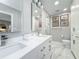 Light-filled bathroom with double vanity, marble floors, and glass-enclosed shower at 301 23Rd Ne Ave, St Petersburg, FL 33704