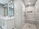 Modern bathroom featuring dual sinks and a spacious walk-in shower with marble tile and built-in bench at 301 23Rd Ne Ave, St Petersburg, FL 33704