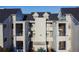 Exterior view of a light gray condominium building with multiple balconies, and a dark roof at 3127 W Sligh Ave # 303B, Tampa, FL 33614