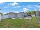View of the backyard featuring a brick patio with fireplace, and fenced yard at 3301 Tuckahoe Pl, Holiday, FL 34690