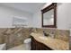 Bathroom with granite countertop vanity and decorative tiled walls at 3301 Tuckahoe Pl, Holiday, FL 34690
