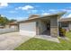 Lovely single-story home featuring a two-car garage, stone veneer details, and a welcoming entrance with tiled walkway at 3301 Tuckahoe Pl, Holiday, FL 34690