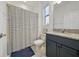 Bathroom featuring a granite countertop, blue cabinets, and a striped shower curtain at 33075 Kateland Dr, Wesley Chapel, FL 33545