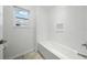 Bright bathroom showcases a clean white tub and a built-in shelf at 33075 Kateland Dr, Wesley Chapel, FL 33545