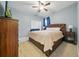 Comfortable bedroom with a brown upholstered bed, TV, and soft carpet flooring at 33075 Kateland Dr, Wesley Chapel, FL 33545