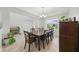 Elegant dining room with dark wood table, seating for eight, and bright natural light from the large window at 33075 Kateland Dr, Wesley Chapel, FL 33545
