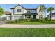This spacious, neutral-toned home has a three-car garage and mature landscaping in the front yard at 33075 Kateland Dr, Wesley Chapel, FL 33545