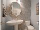 Stylish half bathroom featuring a pedestal sink, toilet, and decorative gold-patterned wallpaper at 33075 Kateland Dr, Wesley Chapel, FL 33545