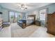 Spacious main bedroom with tiled floor, large windows, and a luxurious upholstered headboard at 33075 Kateland Dr, Wesley Chapel, FL 33545