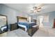 Comfortable main bedroom with blue color scheme, large bed, and decorative ceiling fan at 33075 Kateland Dr, Wesley Chapel, FL 33545