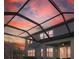 Screened-in lanai features a patio with chairs and table under a ceiling fan to enjoy the outdoors in comfort at 33075 Kateland Dr, Wesley Chapel, FL 33545