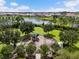 Community playground with slides, swings, and climbing structures near a tranquil pond at 33075 Kateland Dr, Wesley Chapel, FL 33545