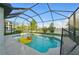 Serene screened-in pool featuring a playful duck floatie and overlooking a scenic backyard and lake at 33075 Kateland Dr, Wesley Chapel, FL 33545