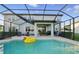 Enclosed pool area featuring a yellow duck float, outdoor seating, and a BBQ grill for entertaining at 33075 Kateland Dr, Wesley Chapel, FL 33545