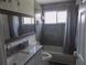 Contemporary bathroom featuring sleek fixtures, gray tile, and a shower-tub combo at 3512 Osprey Cove Dr, Riverview, FL 33578