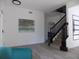 Welcoming entryway with wood-look flooring, a black staircase, and modern decor, offering a stylish introduction to the home at 3512 Osprey Cove Dr, Riverview, FL 33578