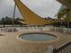 A community hot tub sits on a brick-paved patio underneath a large triangular sunshade at 3512 Osprey Cove Dr, Riverview, FL 33578