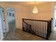 Upper level landing featuring dark wood railings and a decorative chandelier, adding a touch of elegance to the home's interior at 3512 Osprey Cove Dr, Riverview, FL 33578