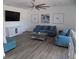 Spacious living room featuring comfortable blue sofas, a modern ceiling fan, and a stylish console beneath a mounted TV at 3512 Osprey Cove Dr, Riverview, FL 33578