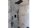 Modern shower area with a rainfall showerhead and stylish marble-tiled walls at 3512 Osprey Cove Dr, Riverview, FL 33578