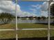 Screened in view of a beautiful lake, white picket fence, and palm trees at 3512 Osprey Cove Dr, Riverview, FL 33578