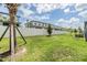 Expansive fenced backyard featuring lush green grass, palm trees, and manicured landscaping, providing a private outdoor space at 36414 Well Hill Way, Zephyrhills, FL 33541