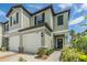 Inviting exterior view of a two-story townhome featuring a well-maintained lawn, attached garage, and charming landscaping at 36414 Well Hill Way, Zephyrhills, FL 33541