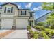 Two-story townhome exterior with attached garage, well-maintained landscaping, and a manicured lawn at 36414 Well Hill Way, Zephyrhills, FL 33541