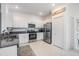 Modern kitchen featuring granite countertops, stainless steel appliances, and white cabinetry at 36414 Well Hill Way, Zephyrhills, FL 33541