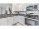 Modern kitchen featuring granite countertops, stainless steel appliances, and white cabinetry at 36414 Well Hill Way, Zephyrhills, FL 33541