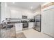 Modern kitchen featuring granite countertops, stainless steel appliances, and white cabinetry at 36414 Well Hill Way, Zephyrhills, FL 33541