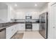 Modern kitchen featuring granite countertops, stainless steel appliances, and white cabinetry at 36414 Well Hill Way, Zephyrhills, FL 33541