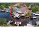 An aerial view of a waterfront home with a private dock and boat lift on a canal at 386 Westwinds Dr, Palm Harbor, FL 34683