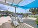 Relaxing backyard deck with comfortable lounge chairs, waterfront view, and overhead shade for ultimate comfort at 386 Westwinds Dr, Palm Harbor, FL 34683