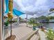 Scenic backyard deck overlooking the water, featuring lounge chairs, potted plants, and relaxing shade at 386 Westwinds Dr, Palm Harbor, FL 34683