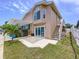 Exterior view of backyard featuring a patio with a hot tub, a small palm tree, and access to a second-floor entrance at 386 Westwinds Dr, Palm Harbor, FL 34683