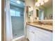 Bathroom featuring a tile shower, a granite vanity, and decorative lighting at 386 Westwinds Dr, Palm Harbor, FL 34683