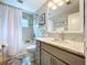 Bathroom boasts a shower-tub combo and a vanity with granite countertops and ample storage at 386 Westwinds Dr, Palm Harbor, FL 34683