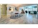 Open dining area with chandelier, a view of stairs, and living space, featuring tiled floors at 386 Westwinds Dr, Palm Harbor, FL 34683