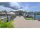 Waterfront property features a private dock with boat lifts and an American flag at 386 Westwinds Dr, Palm Harbor, FL 34683
