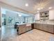 Bright, updated kitchen features a large island with a farmhouse sink and a tile floor extending to the living area at 386 Westwinds Dr, Palm Harbor, FL 34683