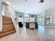 Spacious living room with tile floors, stairs, fan, and sliding glass doors leading to the outdoors at 386 Westwinds Dr, Palm Harbor, FL 34683