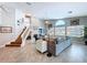 Open-concept living room with a ceiling fan, staircase, statement fireplace, and an abundance of natural light at 386 Westwinds Dr, Palm Harbor, FL 34683