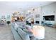 Bright living room with a ceiling fan, fireplace, staircase, and access to other living areas of the home at 386 Westwinds Dr, Palm Harbor, FL 34683