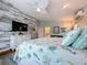 Main bedroom has plank floors, coastal style furnishings, and an accent wall with a flat screen television at 386 Westwinds Dr, Palm Harbor, FL 34683