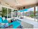 Comfortable sunroom featuring ample seating, coastal-themed decor, and beautiful views of the outdoor deck and canal at 386 Westwinds Dr, Palm Harbor, FL 34683