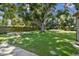 Large backyard with fire pit, lush grass, mature trees, and a fence at 4009 S Renellie Dr, Tampa, FL 33611